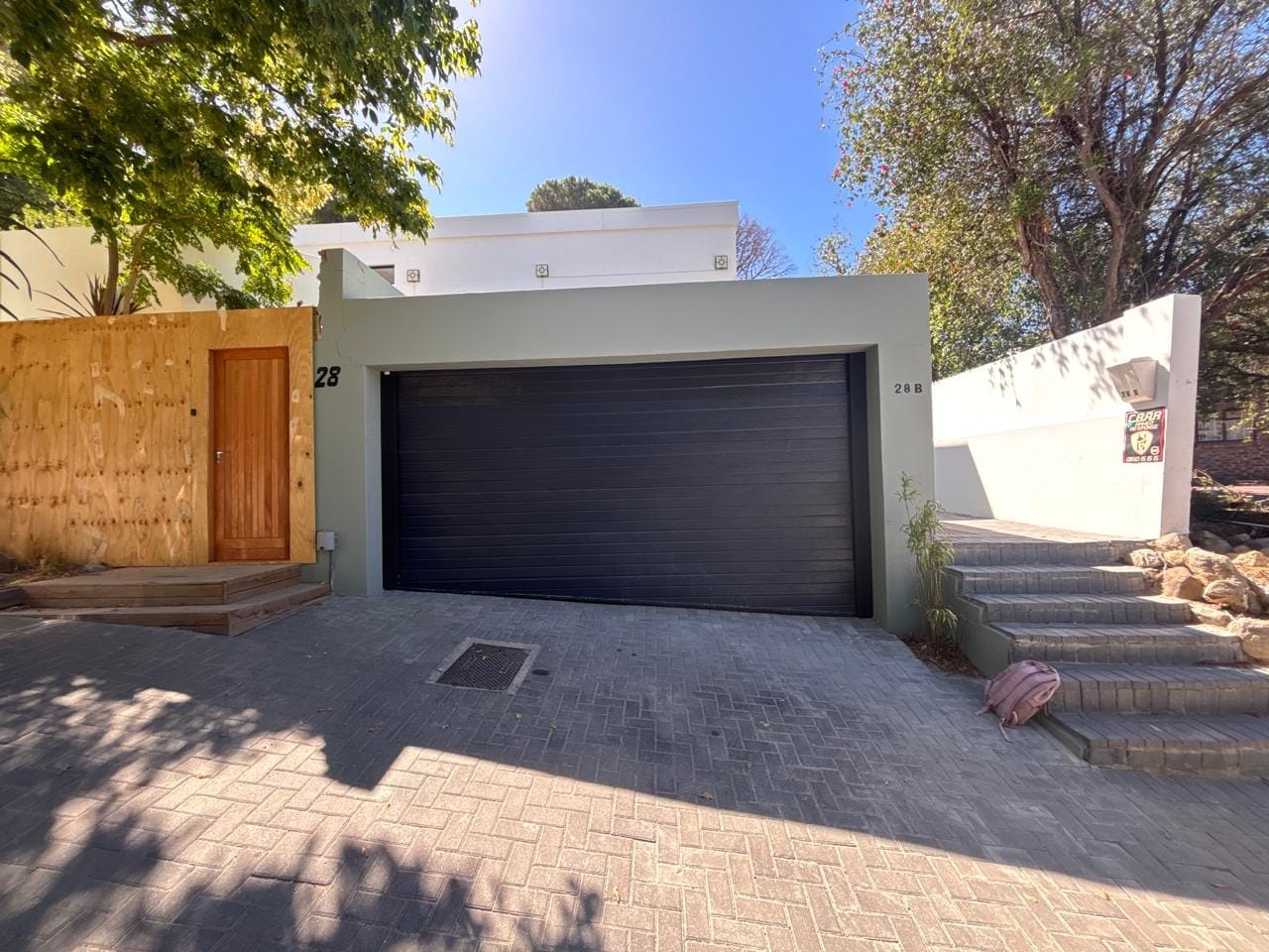 Dark sectional garage door on a Cape Town street frontage