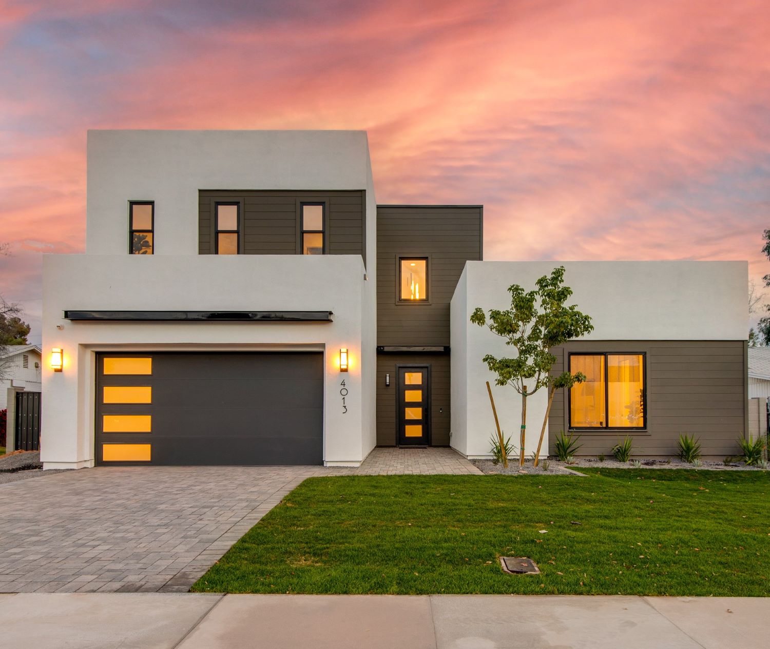 Modern home with a newly installed sectional garage door at dusk