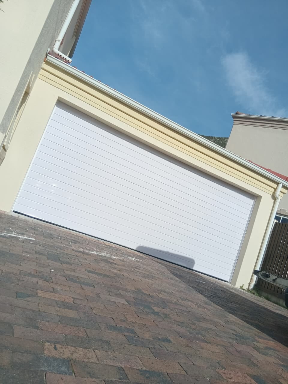 White double garage door fitted on a clear Cape Town day