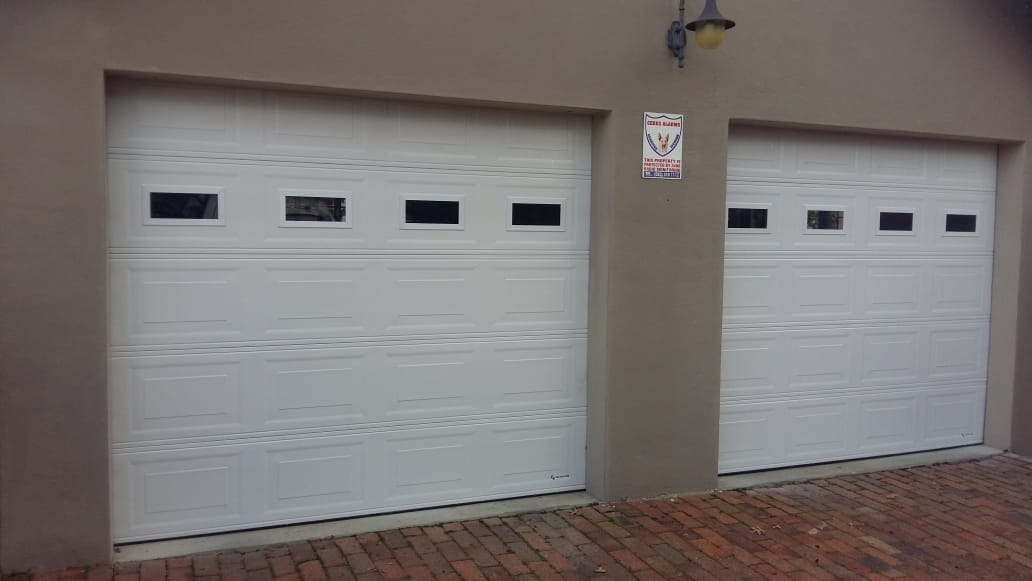 White raised-panel garage doors with window inserts