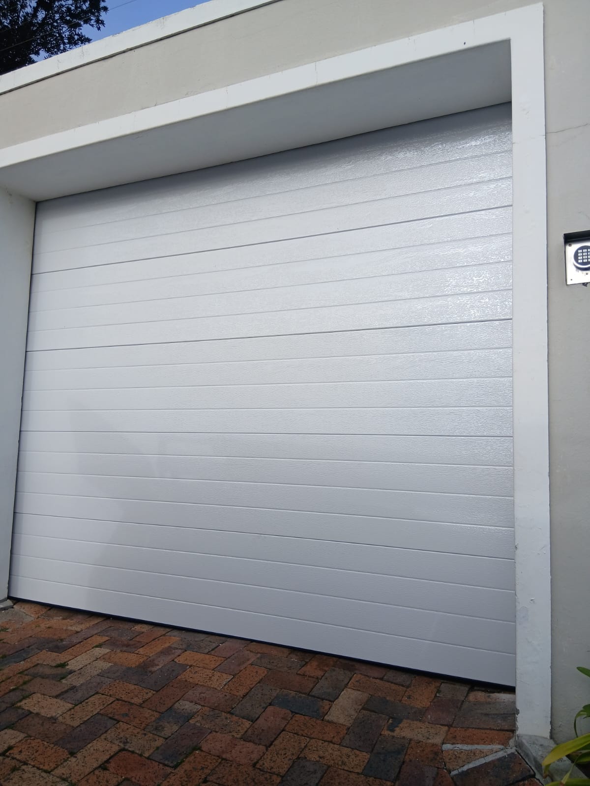 White sectional garage door with keypad access